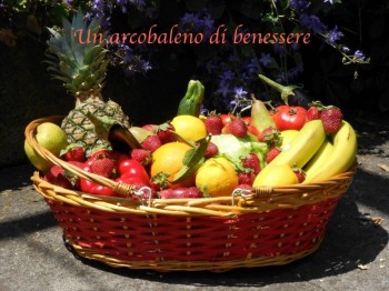 cesto con frutta e verdura di stagione tra cui banane, ananas, limoni, pomodori rossi