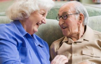 coppia di anziani che ride sul divano