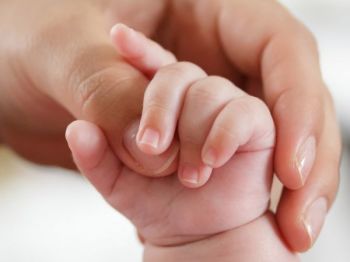mamma e neonato mano nella mano